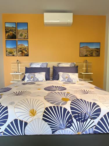 a bedroom with a large bed with blue and white blankets at Entre Mer Et Pinède Piscine in Bandol