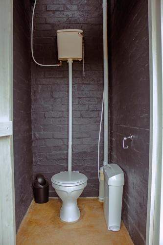 a bathroom with a toilet and a trash can at Karoo 62 Escape - A-frame in Ladismith