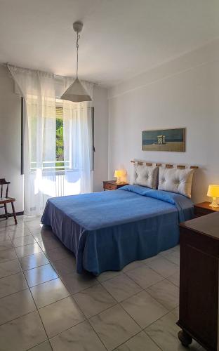 a bedroom with a blue bed and a large window at Miramare Apartment in Ancona