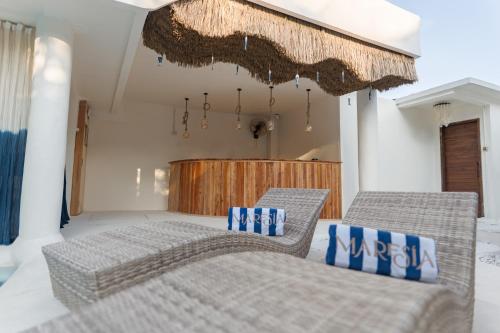 a bedroom with two beds and two wicker chairs at Maresia in Gili Islands
