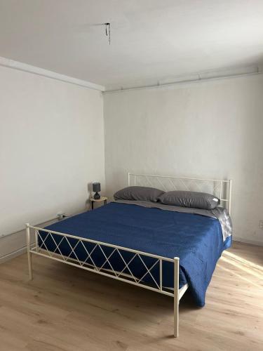 a bedroom with a bed with a blue blanket at Pola's House Biella Bio in Biella