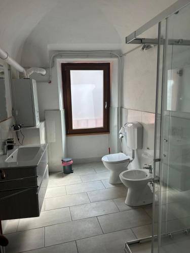 a bathroom with two toilets and a shower and a window at Pola's House Biella Bio in Biella