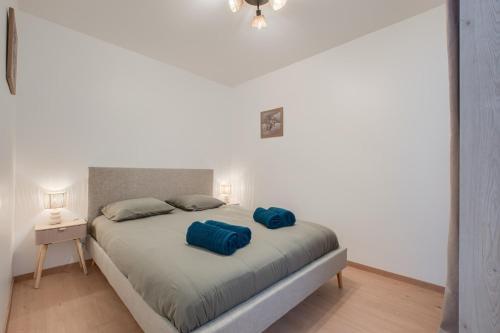a bedroom with a bed with two blue pillows on it at Le Cocon de Cossé - Wifi - 300m Centre in Cossé-le-Vivien