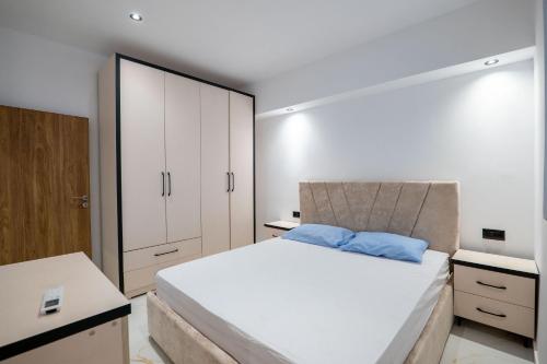 a bedroom with a large bed and white cabinets at Lina's House in Sarandë