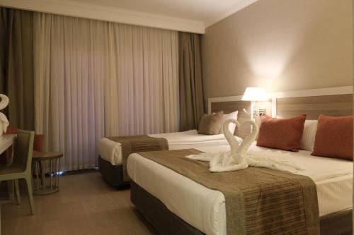 a hotel room with two beds with swans on them at LRS Hotels Port River Hotel & Spa - Ultra All Inclusive in Side