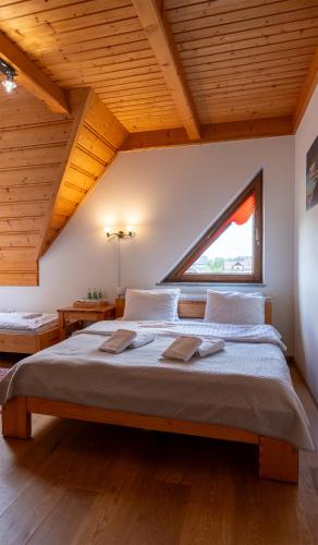 a large bed in a room with a large window at Willa na Borku in Ciche