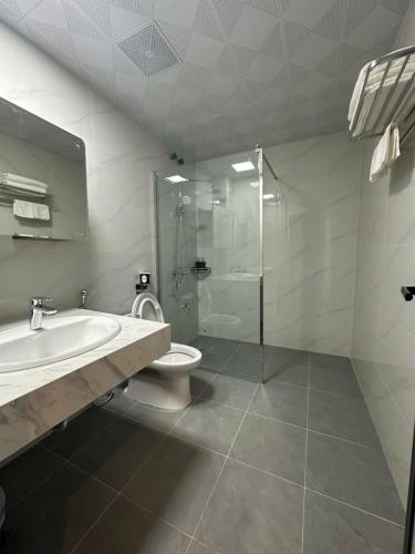a bathroom with a toilet and a sink and a shower at Khách Sạn Ka Long in Móng Cái