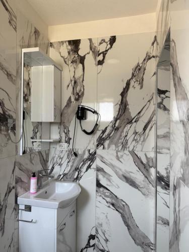 a bathroom with a black and white marble wall at Rezidenca Inspire in Tirana