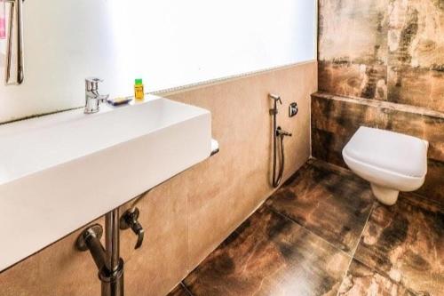 a bathroom with a sink and a toilet at Hotel Annex International Near International Airport in Mumbai