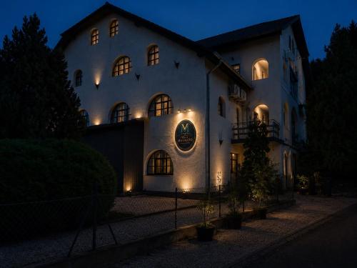 a large white building with lights on it at night at Villa Malazzo in Balatongyörök