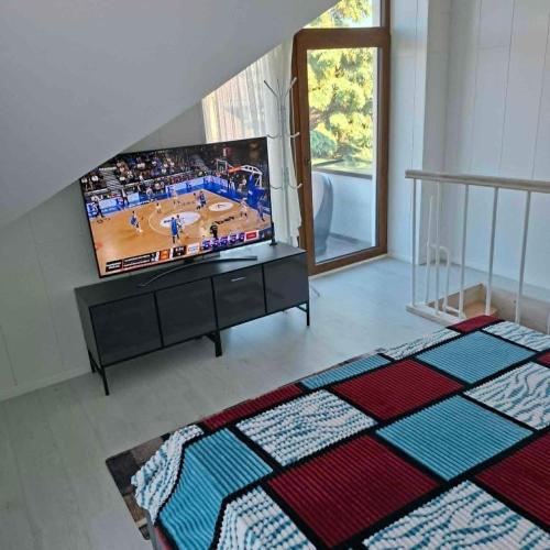 a living room with a flat screen tv and a bed at Melnaragė in Melnragė