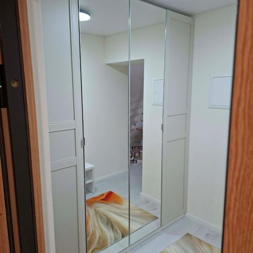 a glass cabinet in a room with a closet at Melnaragė in Melnragė