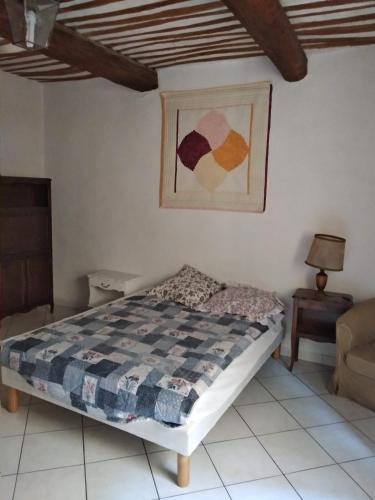 a bedroom with a bed and a chair in a room at La Casa in Montagnac
