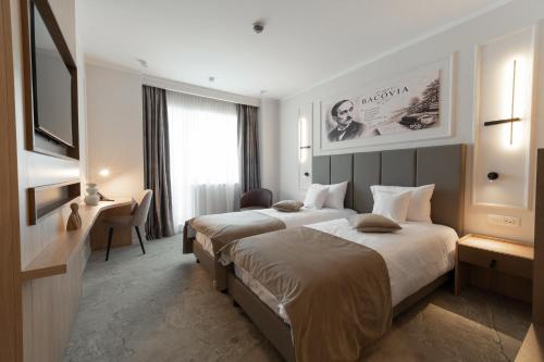 a hotel room with two beds and a television at Hotel Decebal in Bacău