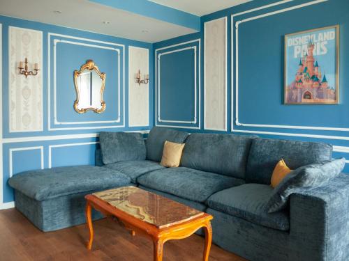 a blue living room with a couch and a table at Disneyland Magic Home in Couilly-Pont-aux-Dames