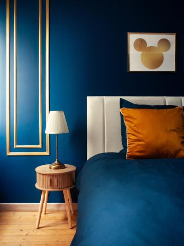 a blue bedroom with a bed and a table with a lamp at Disneyland Magic Home in Couilly-Pont-aux-Dames