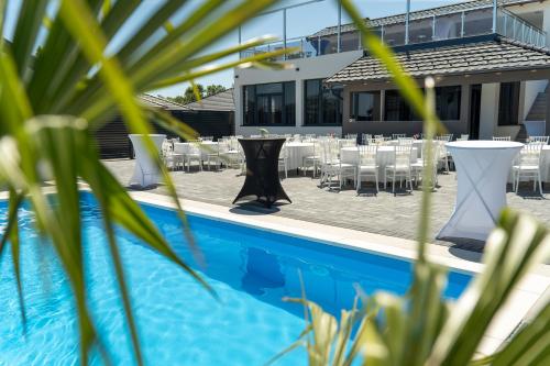 a view of a pool with tables and chairs at Villa Azure Sea in Bijeljina