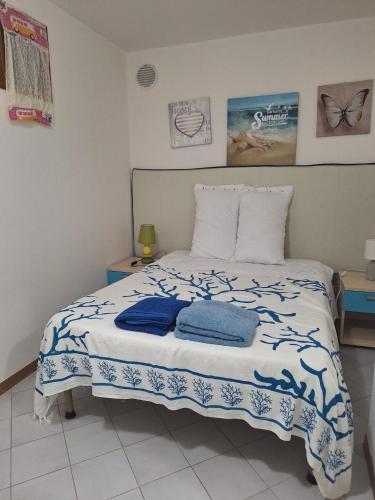 a bedroom with a bed with two towels on it at Villetta La Ginestra in Stintino