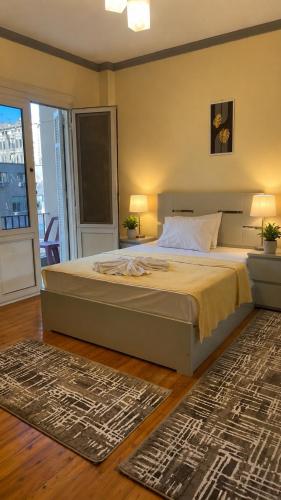 a bedroom with a large bed and a balcony at Stay Ra3 Suites in Cairo