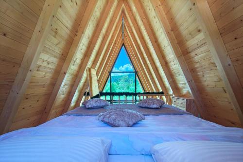 a bed in a room with a large window at Wolf Ridge Mountain Cabin Montenegro in Plužine