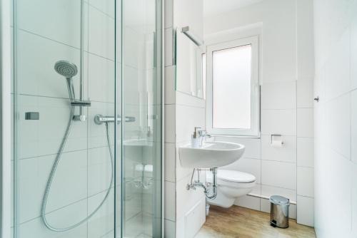 a white bathroom with a shower and a sink at Bodeapartment 8 in Elend