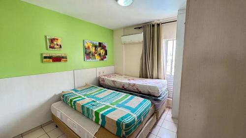 two twin beds in a room with green walls at CRCN - Eldorado Thermas Park in Caldas Novas