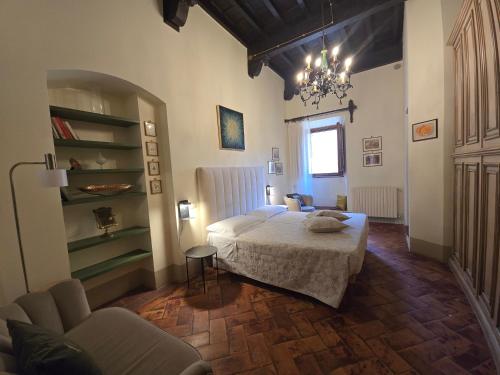 a bedroom with a bed and a couch and a chair at Finestra Dell'Angelo in Pienza