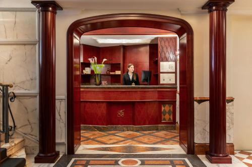 a woman in a mirror in a hotel lobby at The Britannia Hotel in Rome