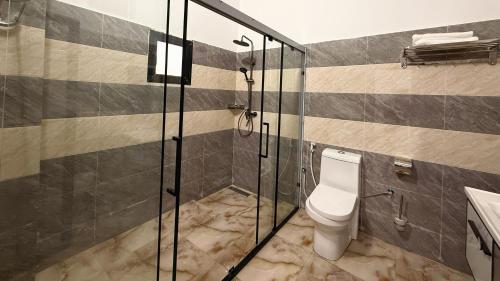 a bathroom with a toilet and a glass shower at Hôtel Mandela Nouakchott in Nouakchott