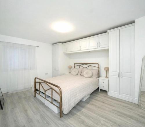 a white bedroom with a bed with pillows on it at 1 Bed Apartment Sleeps 2 -Free Parking -WiFi & Tv in Sutton Coldfield