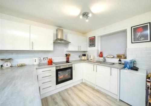 a kitchen with white cabinets and a stove top oven at 1 Bed Apartment Sleeps 2 -Free Parking -WiFi & Tv in Sutton Coldfield