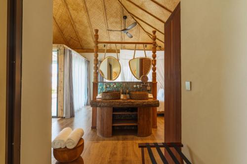 a bathroom with a vanity and mirrors in a room at ENVI Paje Wellness Lodge in Paje