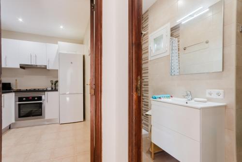a kitchen with a white refrigerator and a sink at Holiday Home Marina 9 in Portals Nous