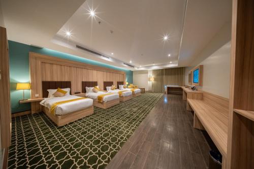 a hotel room with four beds in a row at Continent Al Marzam in Medina