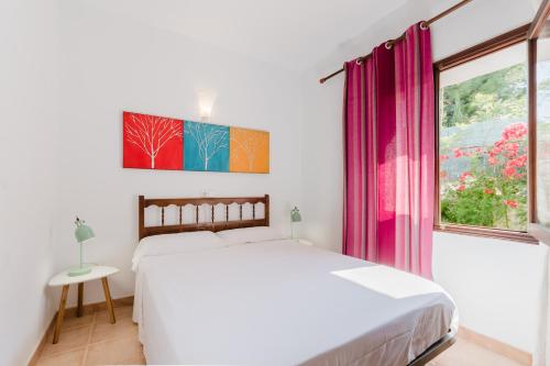 a white bedroom with a bed and a window at Holiday Home Marina 9 in Portals Nous