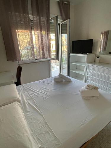 a bedroom with a large white bed with towels on it at A casa mia in Gaeta