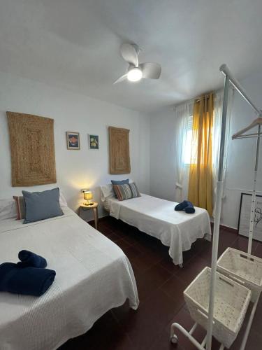 a bedroom with two beds and a ceiling fan at Marenga in El Rompido