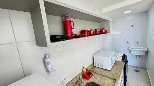 a small kitchen with a sink and a microwave at CRCN - Evian Thermas Residence in Caldas Novas