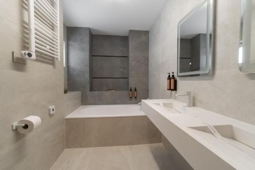 a bathroom with two sinks and a bath tub at Hotel Decebal in Bacău