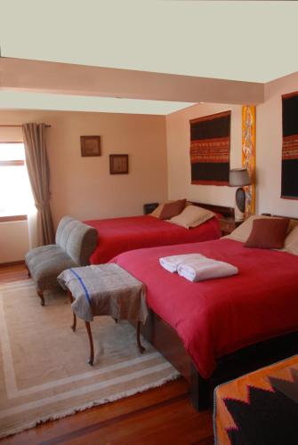 a bedroom with two beds with red sheets at Rendezvous Hostal in La Paz