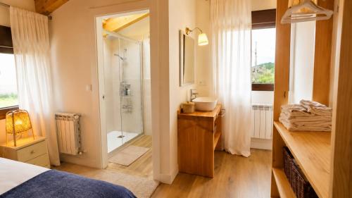 a bathroom with a shower and a sink and a bed at La Casina de San Pedro Ribadesella in Ribadesella