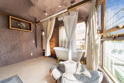 a bathroom with a bath tub and a sink at OXY Cave Homestay Mũi Né in Mui Ne
