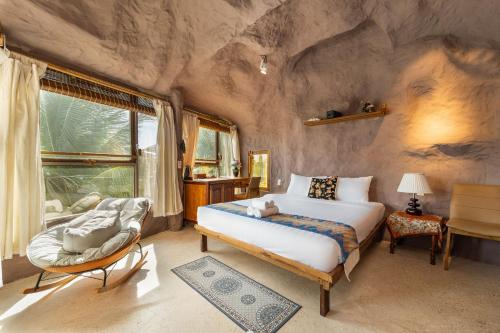 a bedroom with a large bed in a rock wall at OXY Cave Homestay Mũi Né in Mui Ne