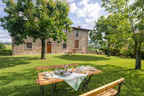 a picnic table in front of a stone house at La Pietraia by VacaVilla in Poppi