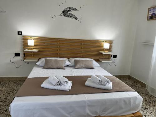 a bedroom with two white towels on a bed at Pellegrino House in Palermo