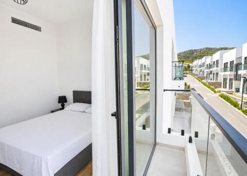 a bedroom with a bed and a balcony at Aqualina C3-4 by HolidayKeys in Kyrenia