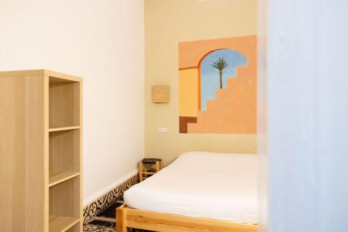a bedroom with a bed and a book shelf at Hostel La Smala in Essaouira