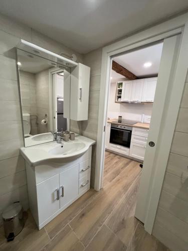 a white bathroom with a sink and a mirror at Pr'Tončih in Podgorje