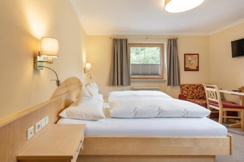 a hotel room with two beds and a desk at Haus Tirol in Tux
