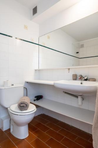a white bathroom with a toilet and a sink at Between sea and Altafulla castle in Altafulla